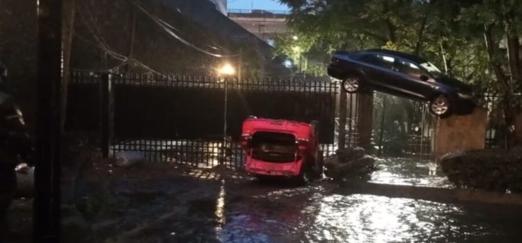 Automóvil termina arriba de reja de 3 metros de altura por las inundaciones